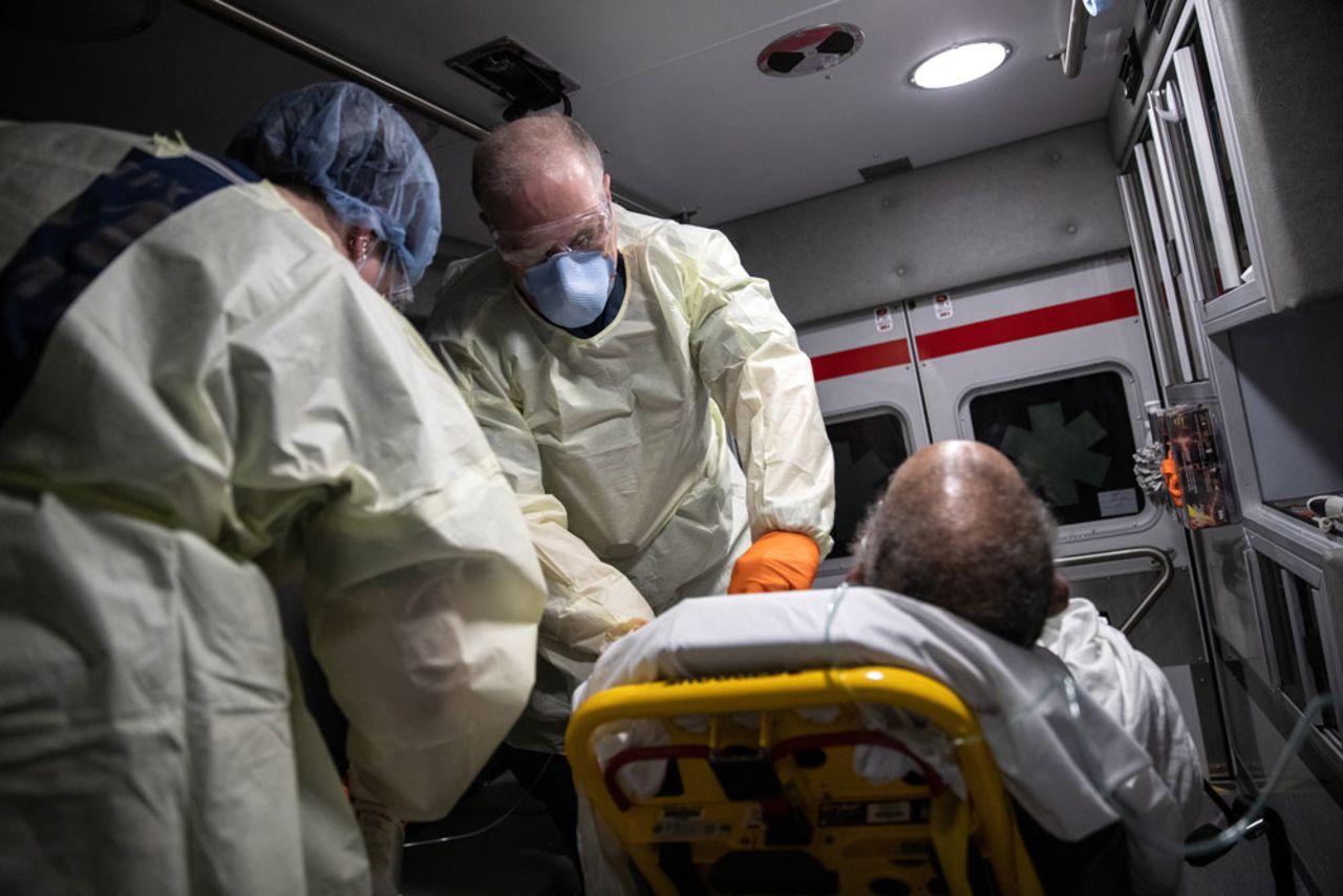Medics wearing personal protection equipment transport an African American patient showing Covid-19 symptoms from his apartment to Stamford Hospital on April 4, in Stamford, Connecticut. 