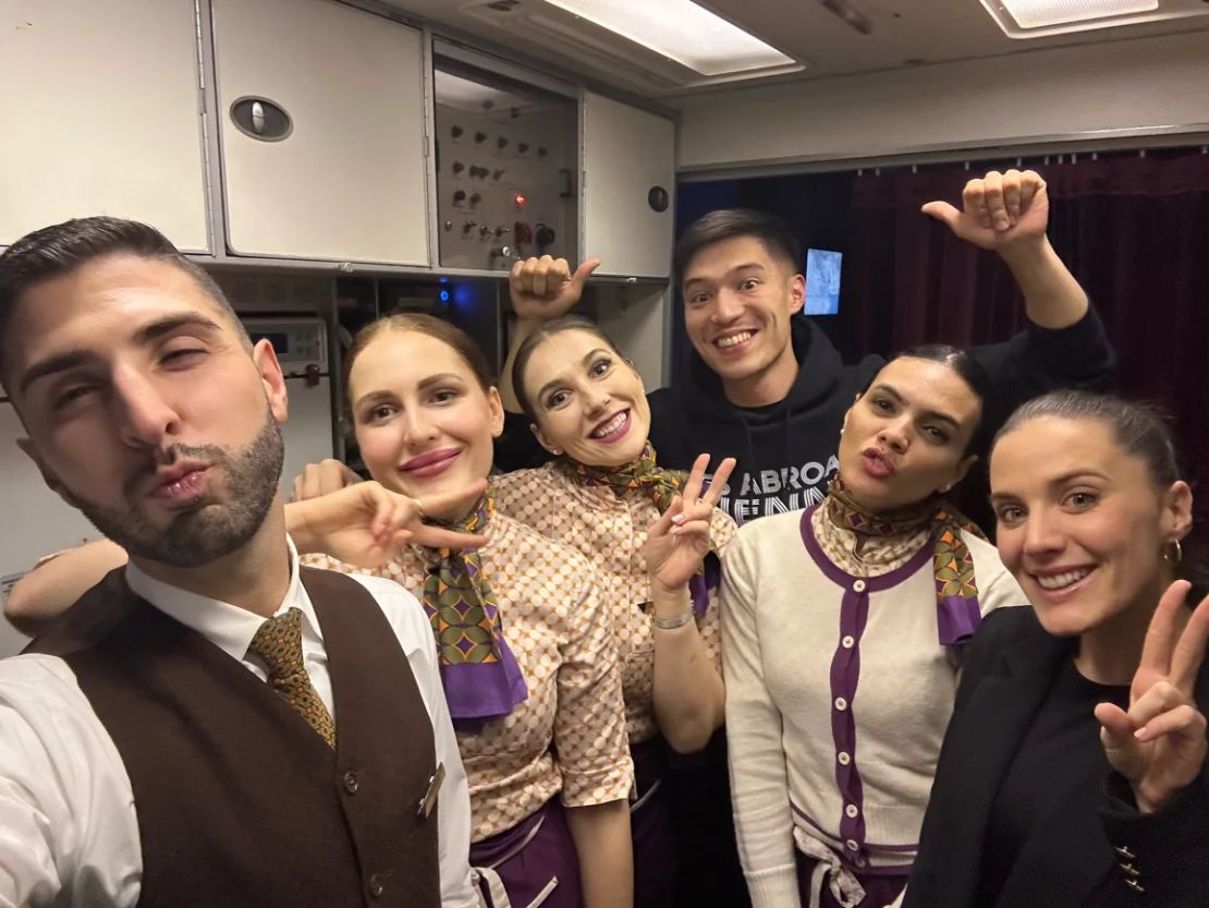 Beleza, posando con la tripulación de cabina durante un vuelo, habla cinco idiomas con fluidez.