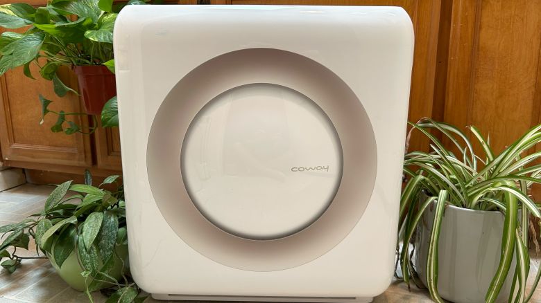 Coway Airmega Mighty air purifier surrounded by plants