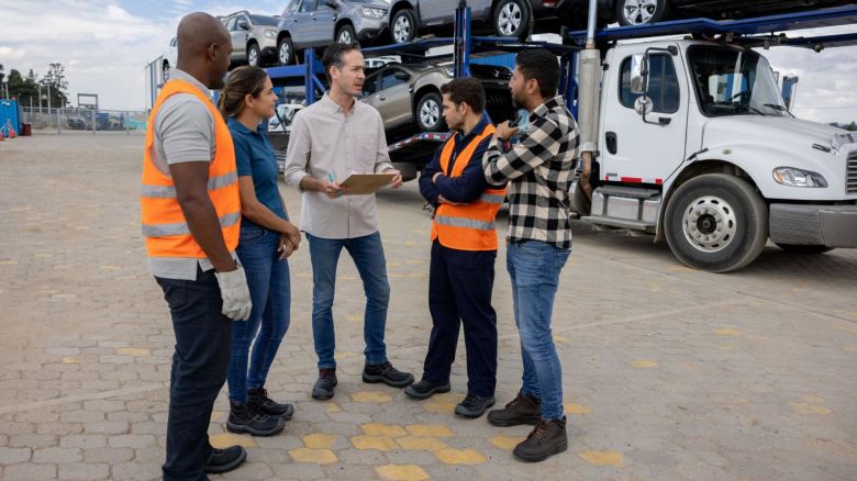 Customers talking with car shipping workers at distribution center