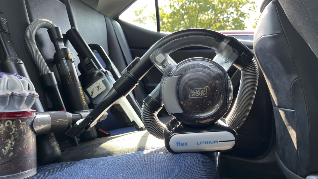 The Black+Decker Max Flex Handheld Vacuum next to a few other vacuums in a car.