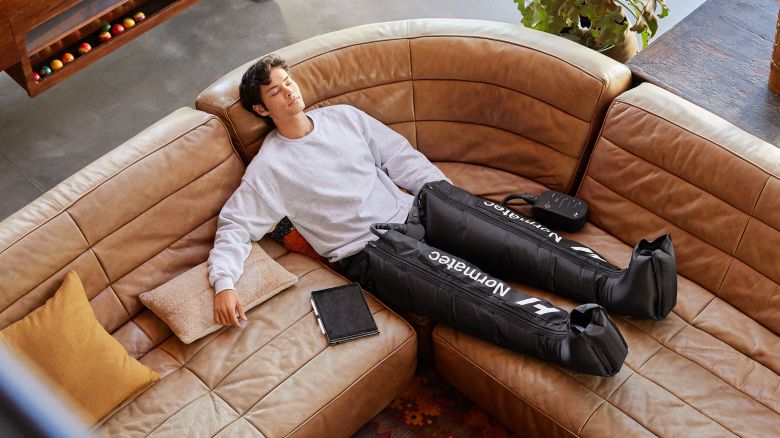 Man sitting on couch with compression boots on.