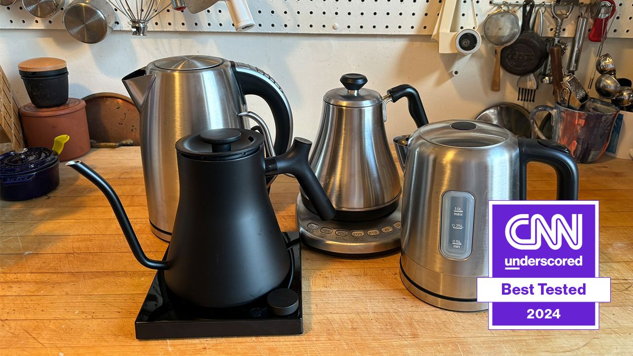 four electric kettles displayed on a table