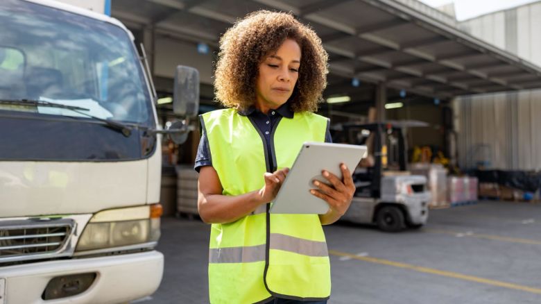 Woman supervises dispatch of moving trucks.