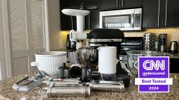 A KitchenAid stand mixer and a collection of its attachments on a countertop.