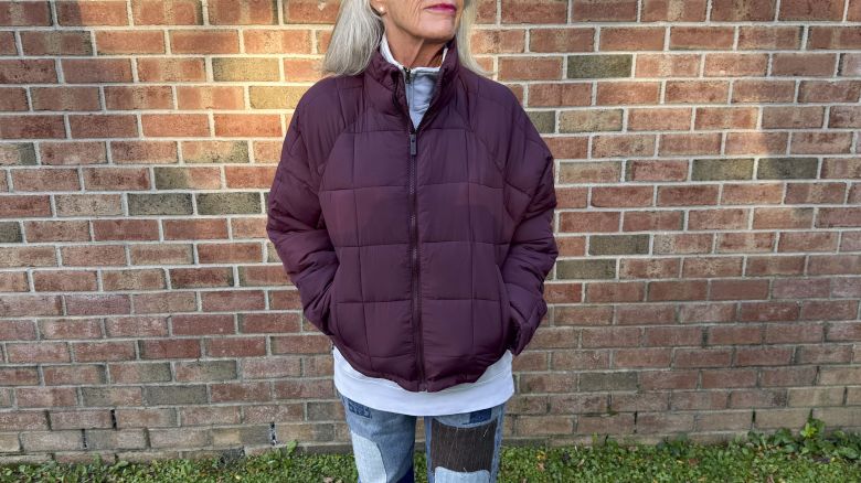 person wearing a maroon colored packable jacket