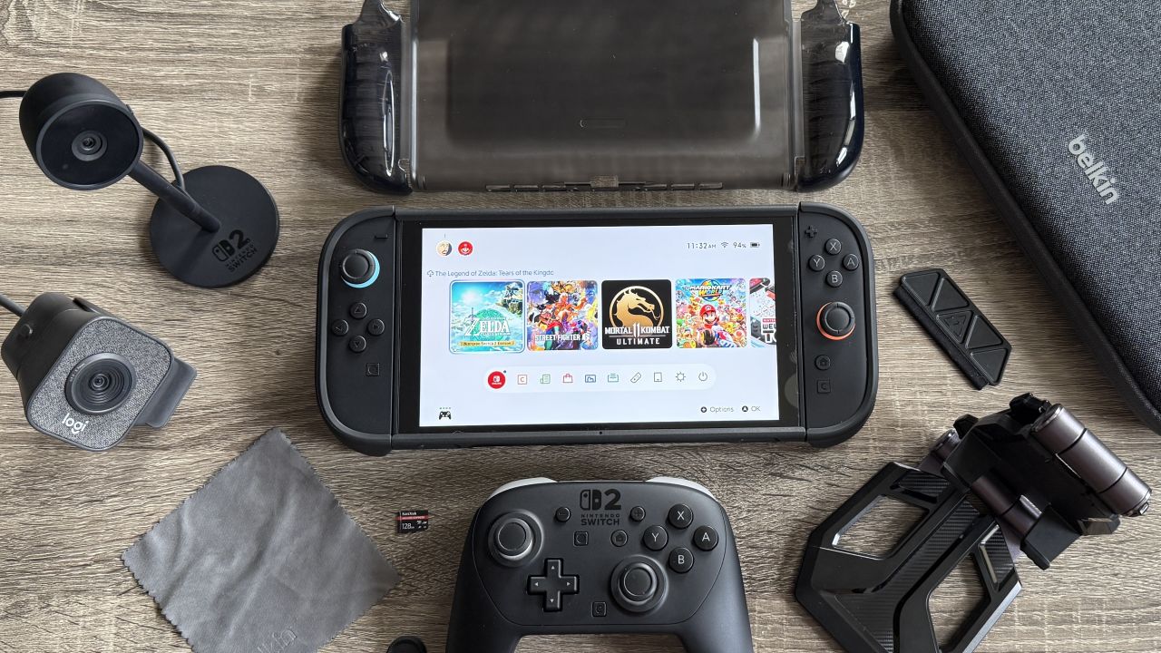 A Nintendo Switch 2 on a table with various cases, stands, controllers and webcams. 
