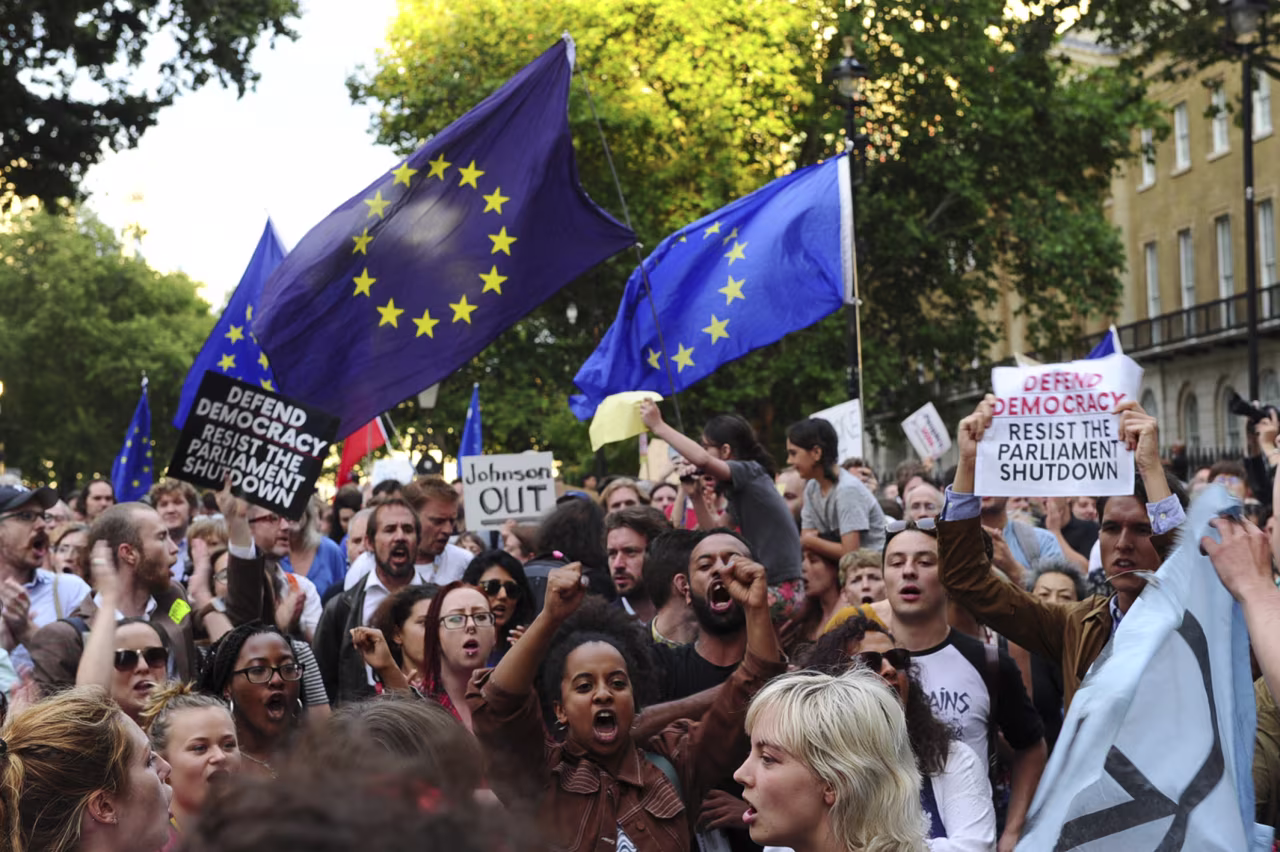Demonstrators wave European Union flags and hold placards as they protest outside of Downing Street in London on August 28.