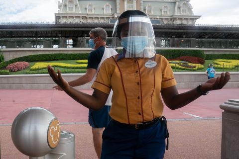 An employee at Walt Disney World Resort's Magic Kingdom wears a face mask and face shield at the entrance to the park on July 23.