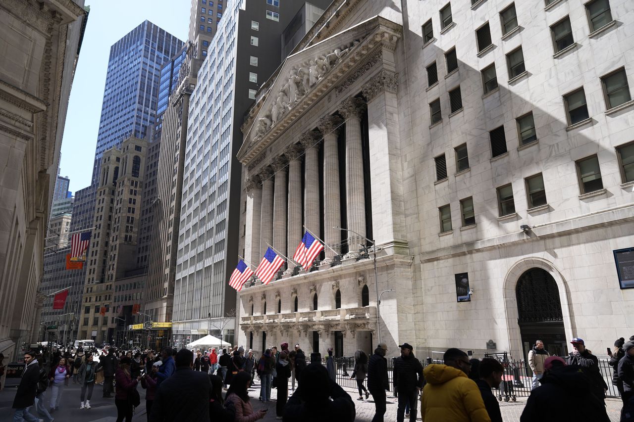 Pedestrians walk past the New York Stock Exchange building on March in New York.