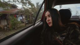 Bianca Balala looks out the window of a car as she passes through her village in the Philippines.