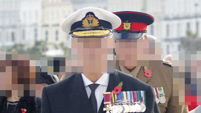 Photos circulated on social media showed the man wearing a black, white and gold cap and a jacket adorned with 12 colorful medals. CNN has blurred portions of this photo to protect individuals’ identities.