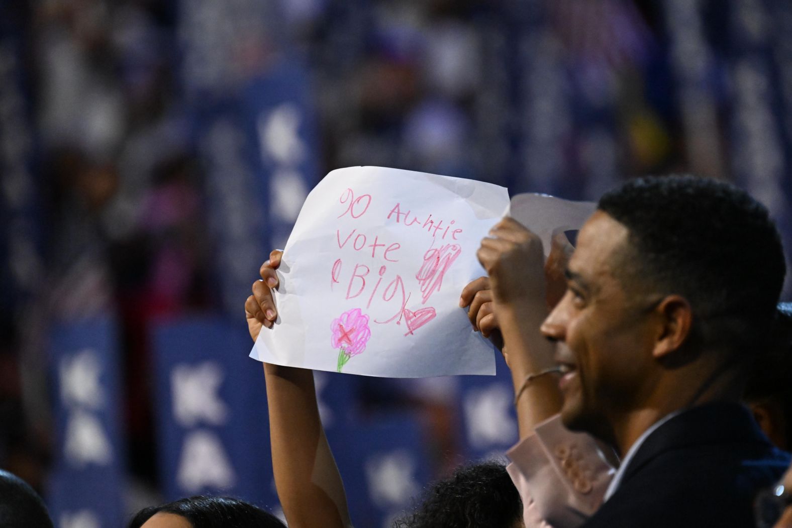 Harris' great-niece holds up a sign that says "go auntie, vote big" as the vice president gives her speech on Thursday.