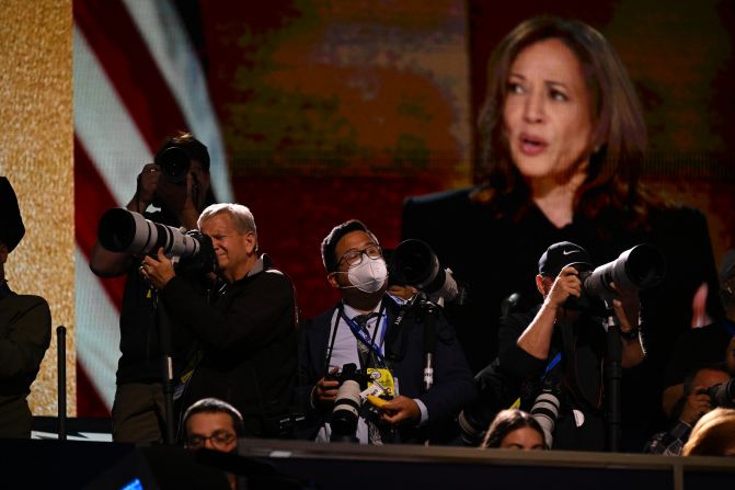 Photographers work during Harris' speech on Thursday.