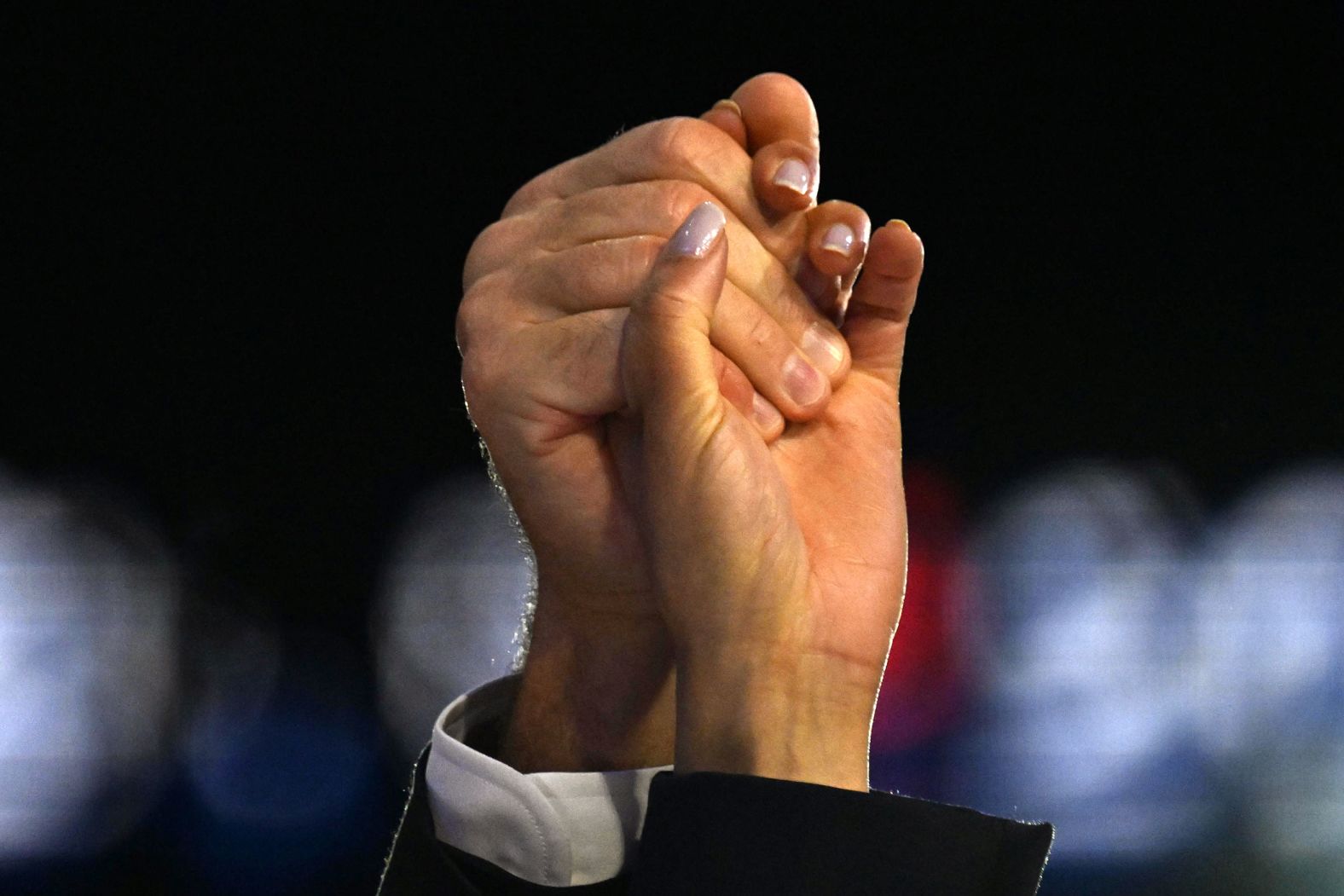 Harris and Walz hold hands after Harris' speech on Thursday.