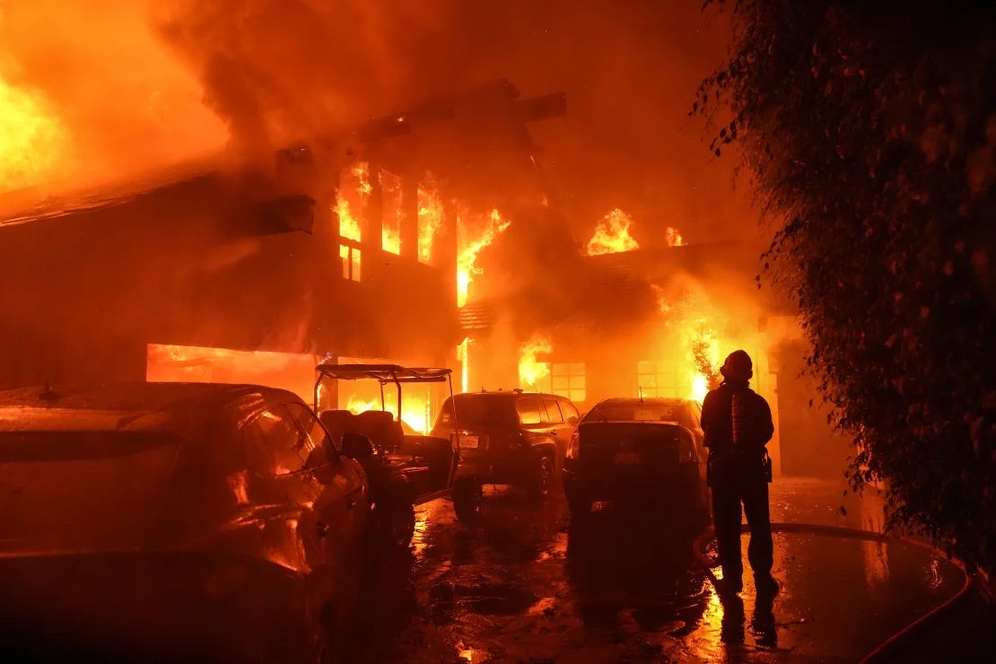 Un bombero rocía agua sobre una casa en Malibu el martes.