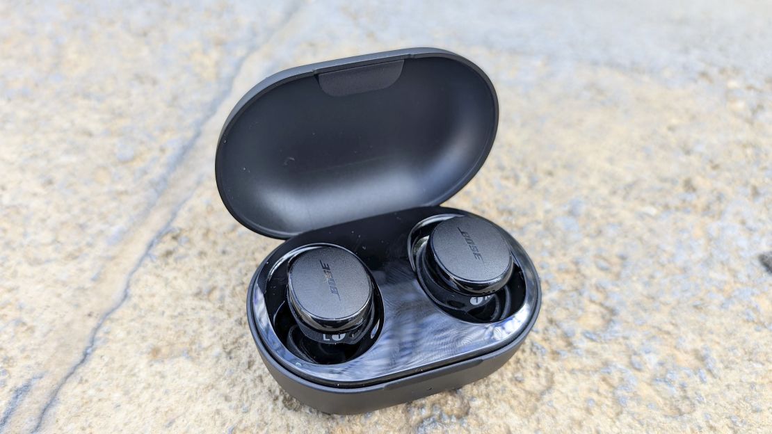 Bose QuietComfort Earbuds and its case on the ground.