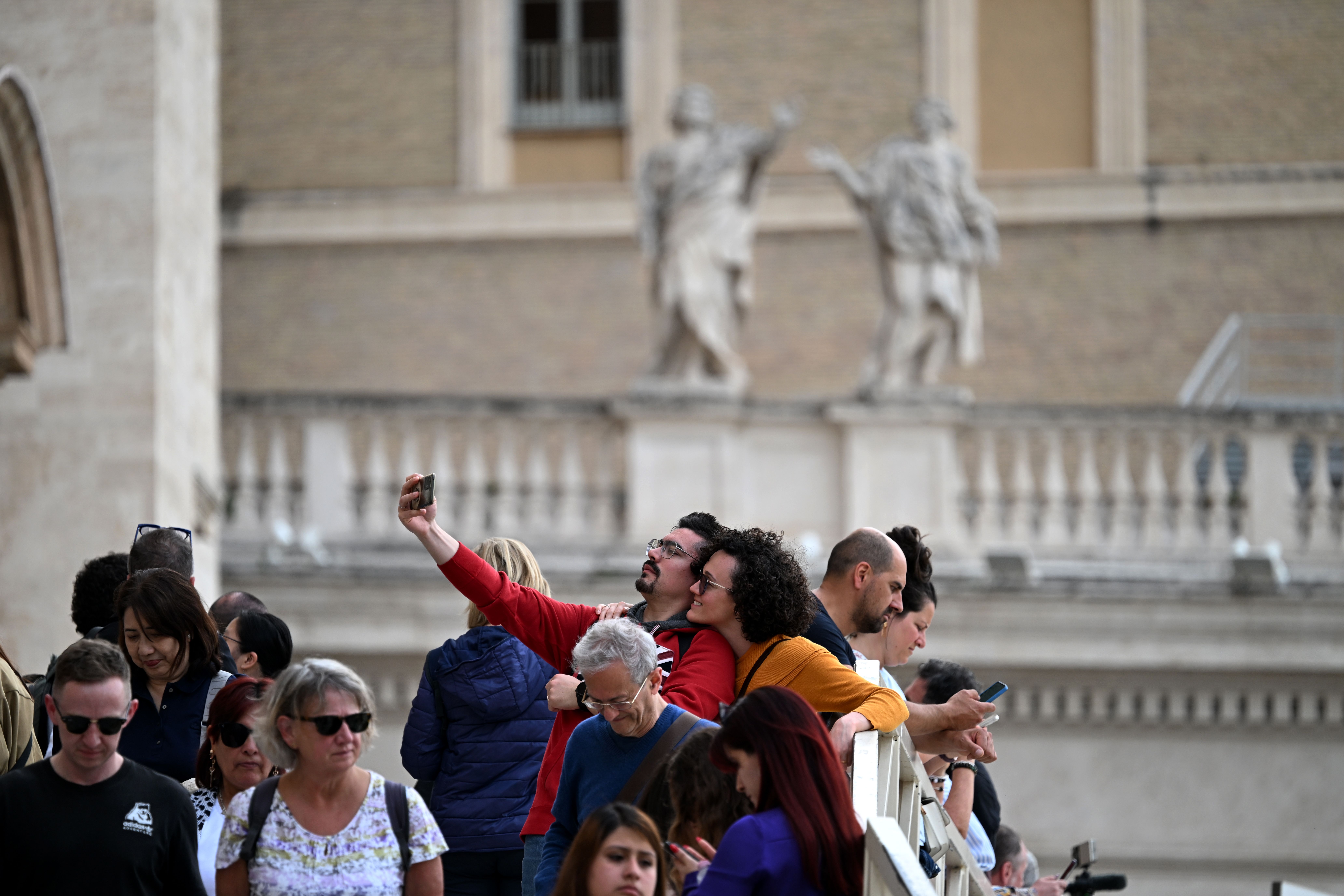 A couple takes a selfie after viewing the pope's body on Wednesday.