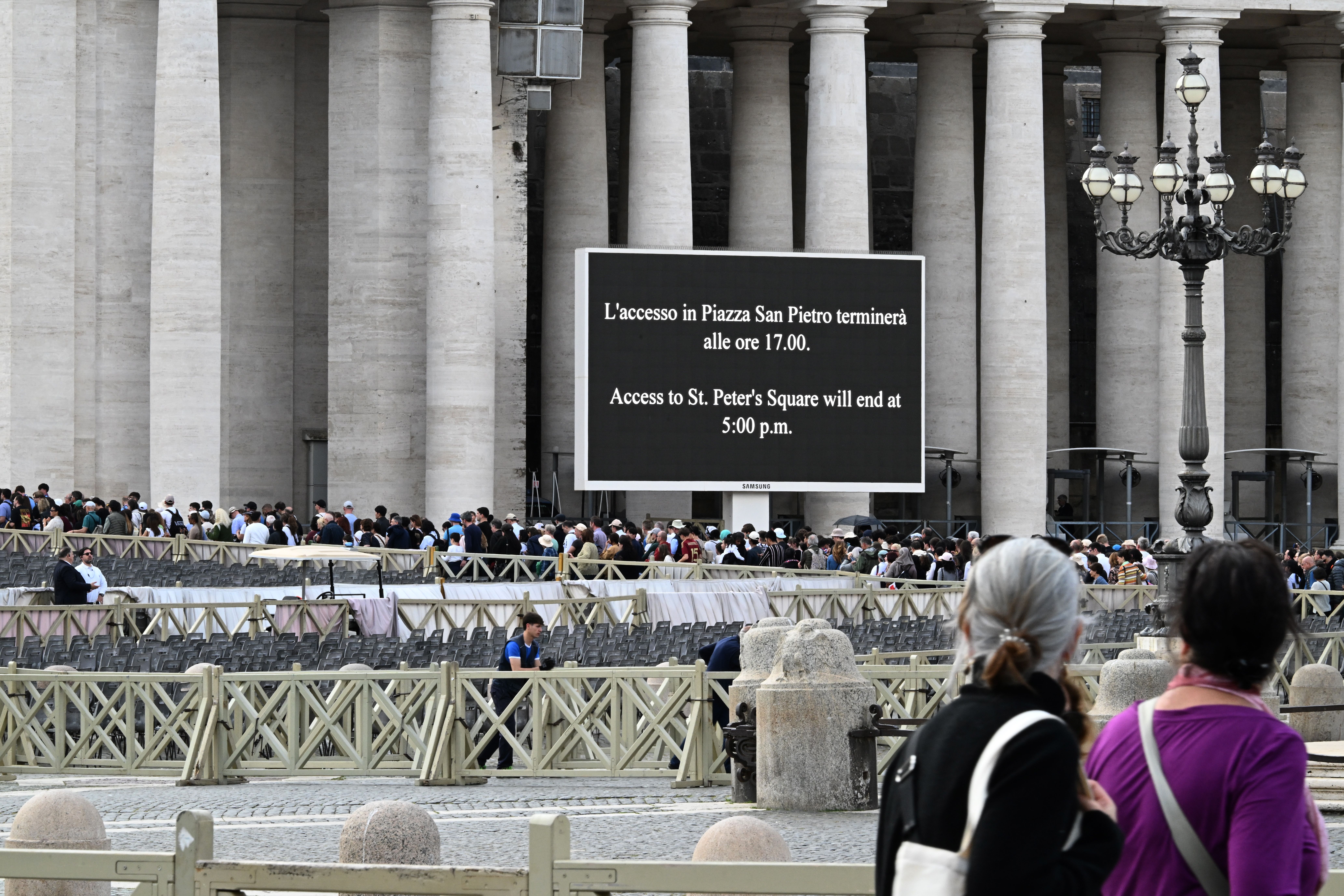 Crowds line up outside St. Peter's Basilica on Friday as a sign indicates the closing of St. Peter's Square.