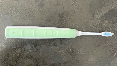 A Brightline Sonic Rechargeable Toothbrush on a stone countertop