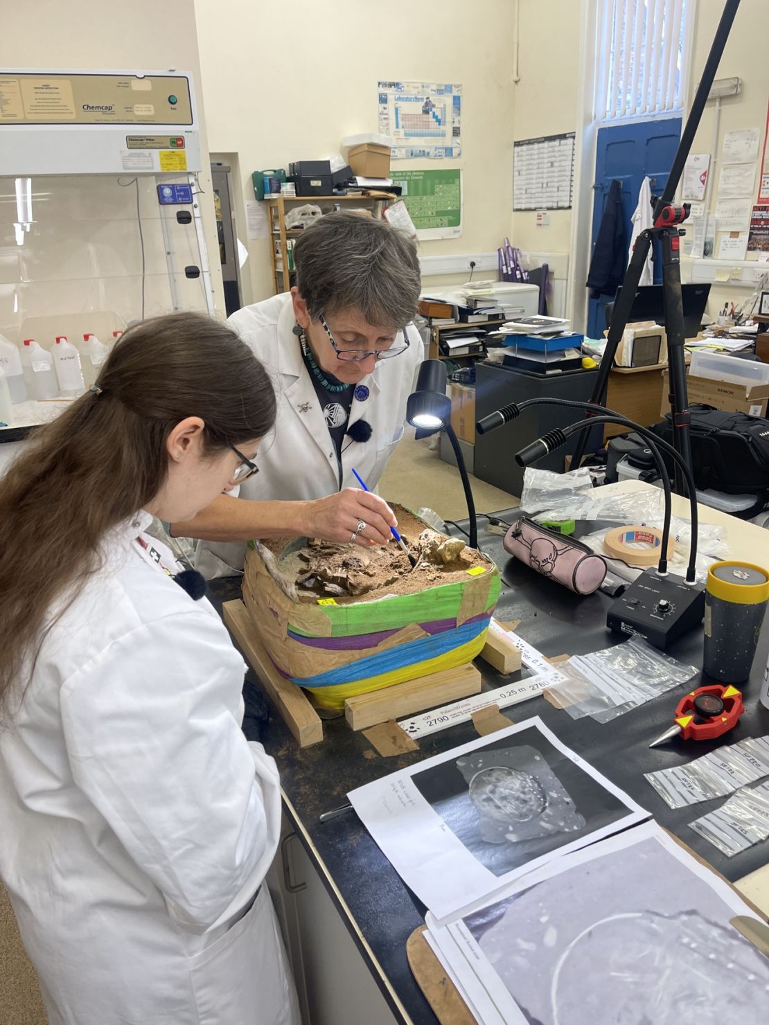 Researchers carefully brush away dirt to uncover the bucket's contents.