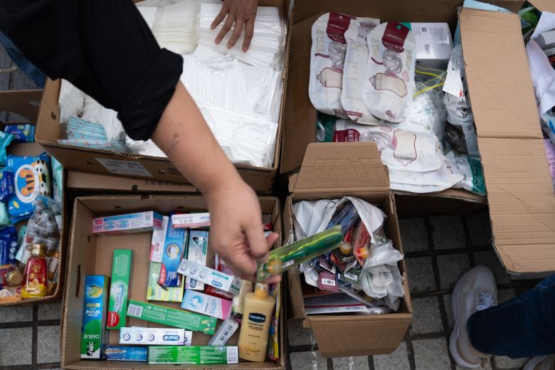 Residents collect donations at a distribution point following the fire in Tai Po, Hong Kong, on November 27, 2025.