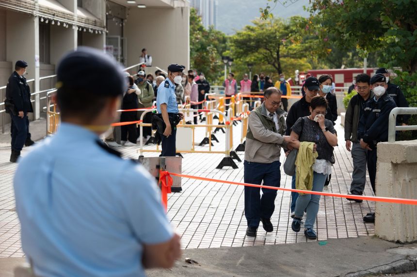Family members wait inline to identify victims from photographs following the fire at Wang Fuk Court housing estate in Tai Po, Hong Kong, on November 27, 2025.