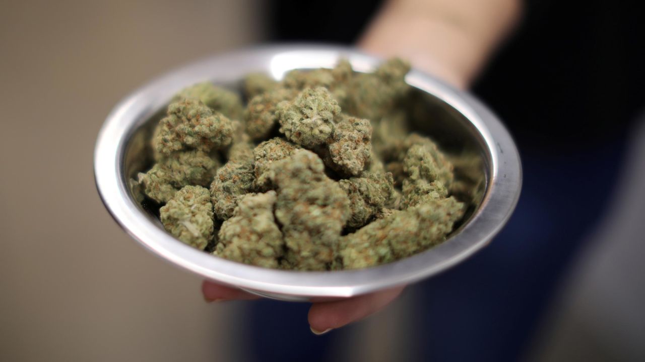 A woman holds marijuana for sale at the MedMen store in West Hollywood, California, in 2018.