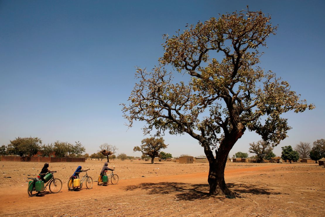 In February 2018, a girl carries water to her bike at a pharmacy in the village of Nedogo, near Burkina Faso, Burkina Faso and Burkina Faso in the Sahel region of Africa. 