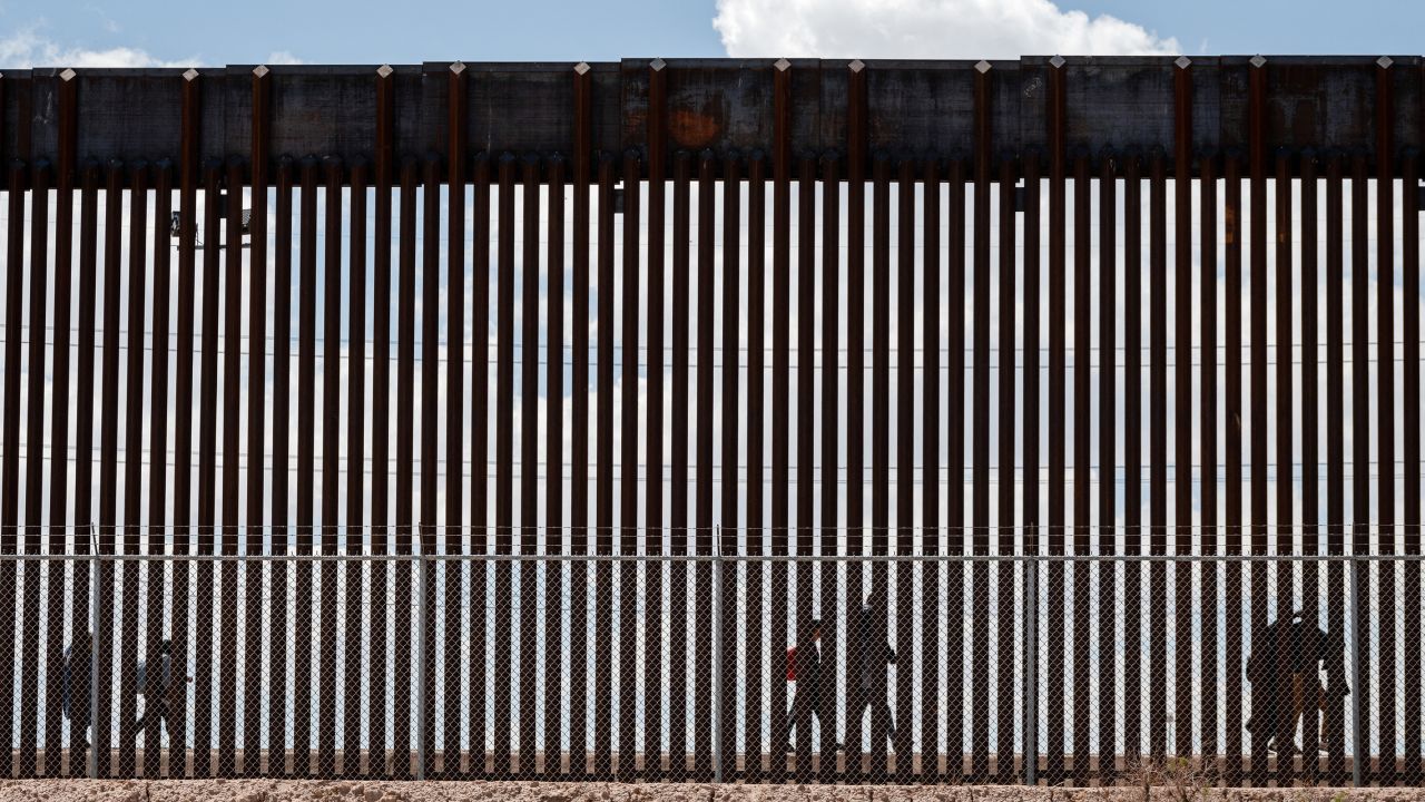 Migrants walk along the Mexico-US border after the the Republican-backed Texas law known as SB 4 took effect on March 19.