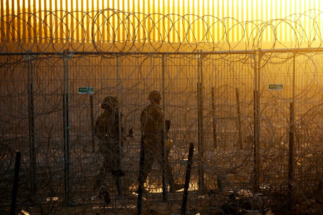 Members of the Texas National Guard stand guard near a razor wire fence to inhibit the crossing of migrants into the United States, seen from Ciudad Juarez, Mexico, on June 4.