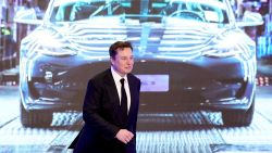 In this January 2020 photo, Tesla CEO Elon Musk walks next to a screen showing an image of Tesla Model 3 car during an opening ceremony for Tesla China-made Model Y program in Shanghai.