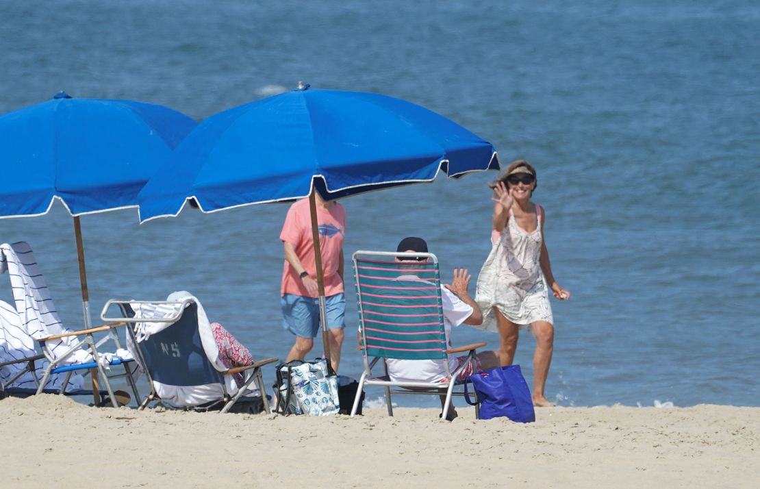 President Joe Biden waves back to a well-wisher while sitting on the beach in Rehoboth, Delaware, on August 28.