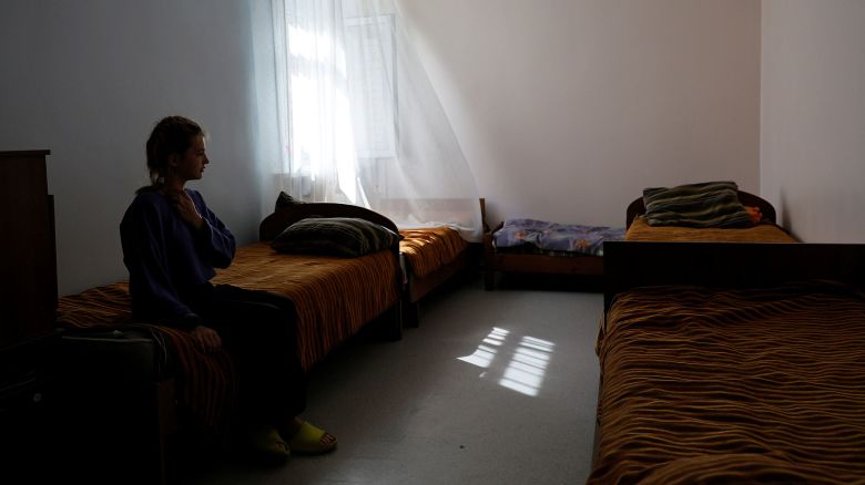 A girl evacuated from the Kursk region along with other children, including those from orphanages, sits on a bed at a temporary accommodation center located in a children's camp in Korolyov outside Moscow, Russia, on August 30, 2024.