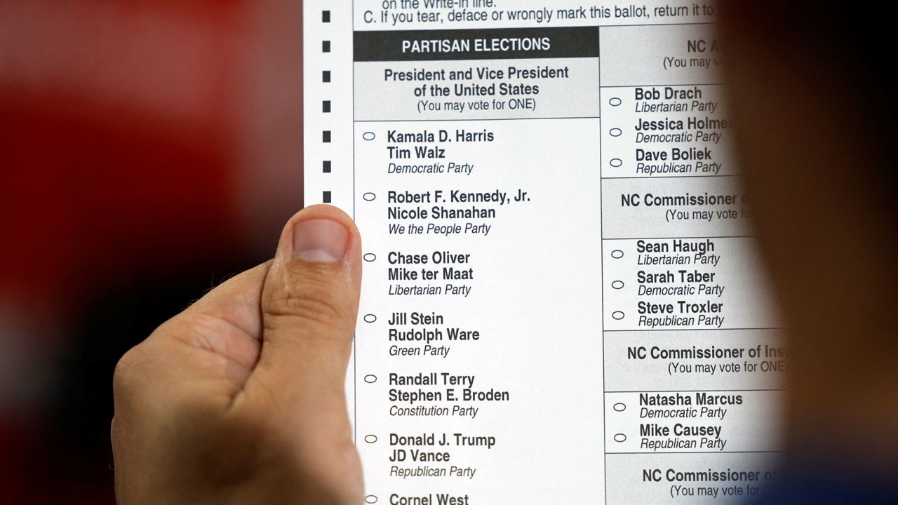 An election worker displays a test ballot listing the US presidential candidates at Wake County Board of Elections headquarters in Raleigh, North Carolina, on September 5.