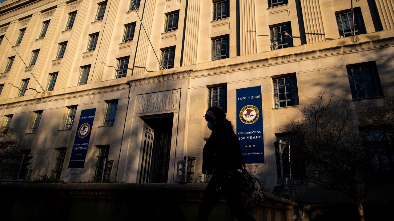 In this 2020 photo, a woman walks past the US Department of Justice in Washington, DC. 