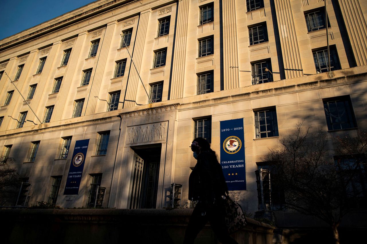 In this 2020 photo, a woman walks past the US Department of Justice in Washington, DC. 