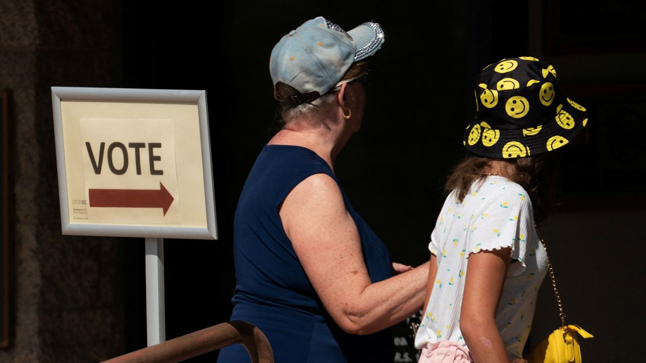 Voters walk towards a polling station to cast their ballots in early voting for the presidential election in Scottsdale, Arizona, on October 10.