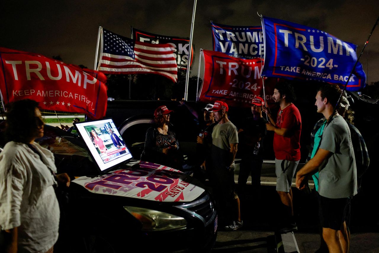 Supporters of former President Donald Trump watch election updates on a screen connected to a car on Election Day, near Mar-a-Lago, in Palm Beach, Florida, on Tuesday.