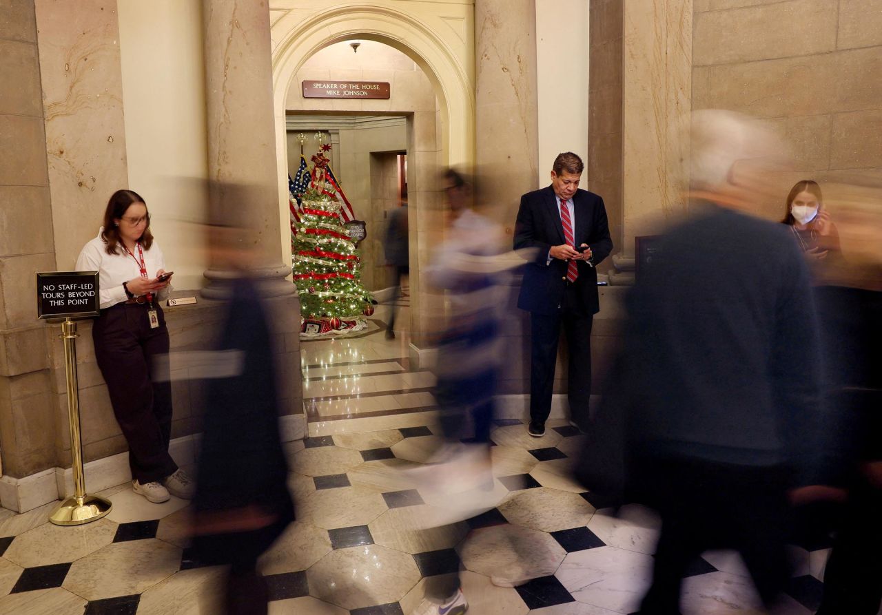 Members of the news media linger outside of the office of House Speaker Mike Johnson after US President-elect Donald Trump called on lawmakers to reject a stopgap bill to keep the government funded past Friday, raising the likelihood of a partial shutdown, on Capitol Hill in Washington, DC, on December 19. 