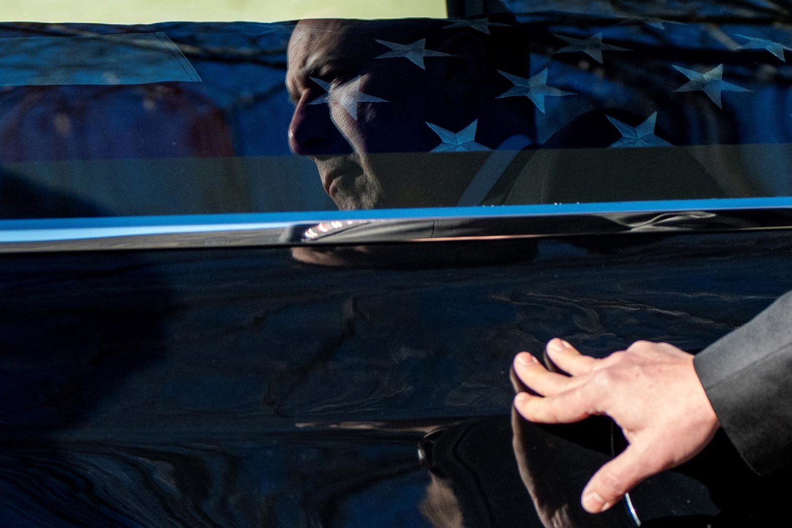 A Secret Service places his hand on the hearse containing Carter's casket at Phoebe Sumter Medical Center in Americus, Georgia, on January 4.