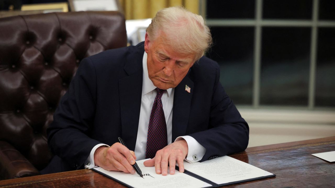 President Donald Trump signs documents as he issues executive orders and pardons for January 6 defendants in the Oval Office at the White House on Inauguration Day in Washington, DC, on January 20.