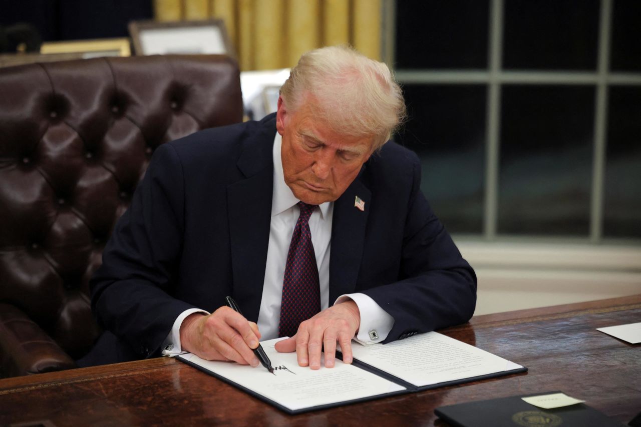 President Donald Trump signs documents as he issues executive orders and pardons for January 6 defendants in the Oval Office at the White House on Inauguration Day in Washington, DC, on January 20.