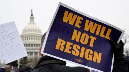 A person displays a sign as labor union activists rally in support of federal workers during a protest, with the US Capitol in the background on Capitol Hill in Washington, DC, on February 11.