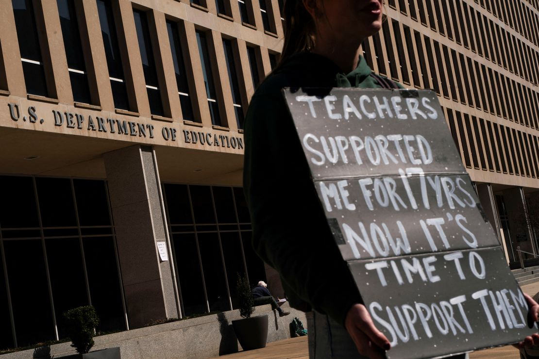 A protester stands near the Department of Education headquarters after the agency said it would lay off nearly half its staff, a possible precursor to closing altogether, as government agencies scrambled to meet President Donald Trump