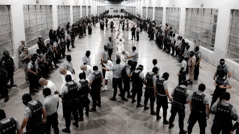 In this handout photo obtained March 16 from El Salvador’s Presidency Press Office, Salvadoran police officers escort alleged members of the Venezuelan gang Tren de Aragua recently deported by the US government.