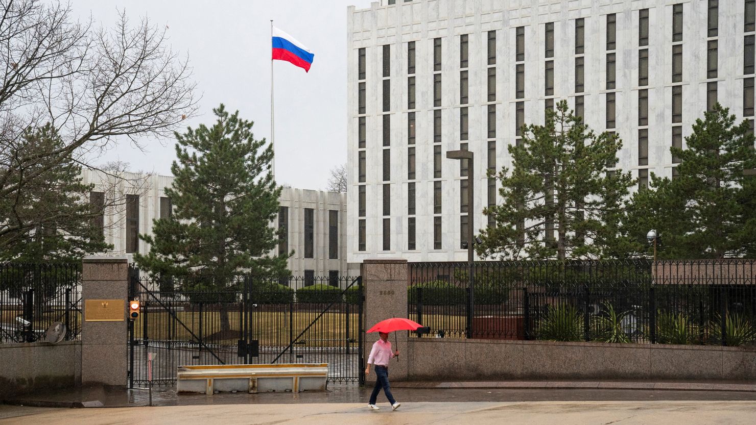 A pedestrian walks with an umbrella outside the Embassy of the Russian Federation, near the Glover Park neighborhood of Washington, DC, in February 2022.