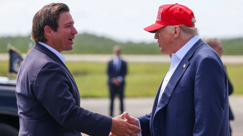President Donald Trump shakes hands with Florida Governor Ron DeSantis at the Dade-Collier Training and Transition Airport on the day of the opening of a temporary migrant detention center informally known as "Alligator Alcatraz" in Ochopee, Florida, on July 1. 