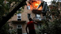 A resident looks on at the site of an apartment building hit during Russian missile and drone strikes in Kyiv, Ukraine, on July 31.