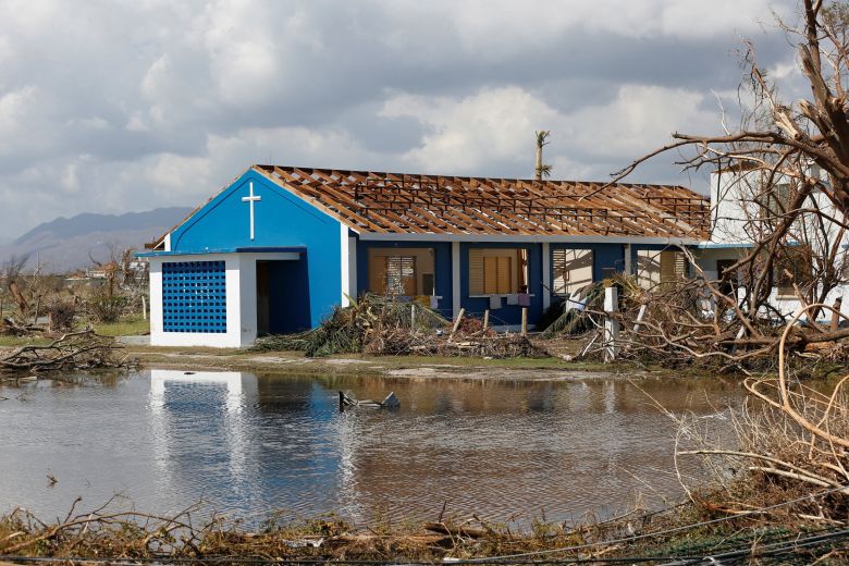 A building stands amid torn tree branches and flooding on Thursday.